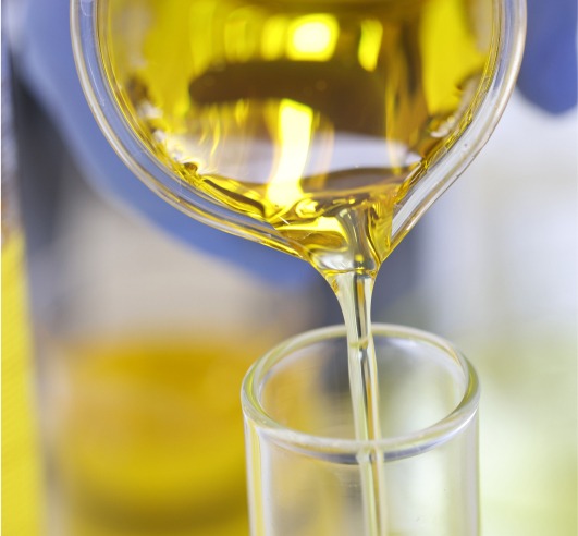 Yellow liquid being poured from a container into a tube.