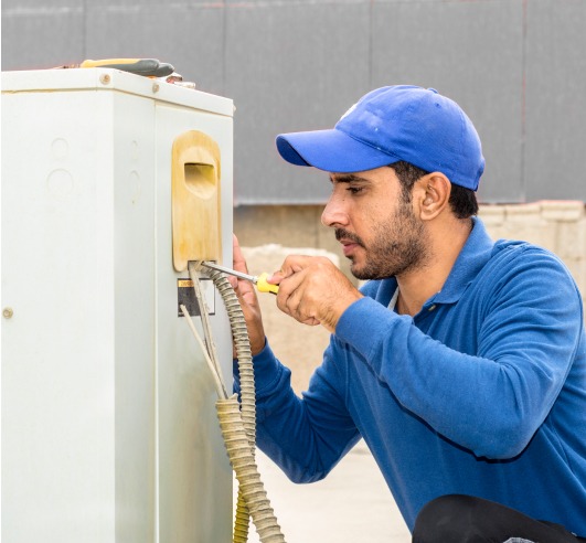 man using a screwdriver to open an electric panel